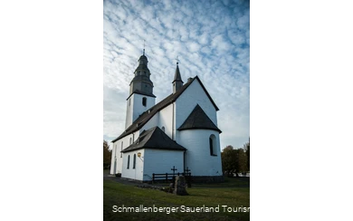 Rückseite der Kirche in Wormbach vor leicht bewölktem Himmel