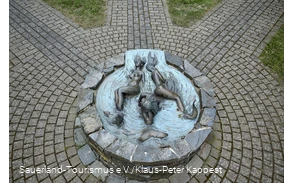 Blick auf den Brunnen mit den drei Nornen, den Schicksalsgöttinnen der Germanen