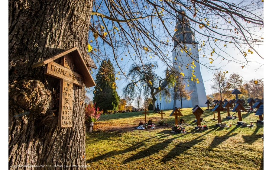 Sauerland-Wanderdörfer, Kirche in Wormbach mit Fokus auf einen Baum mit Kreuz