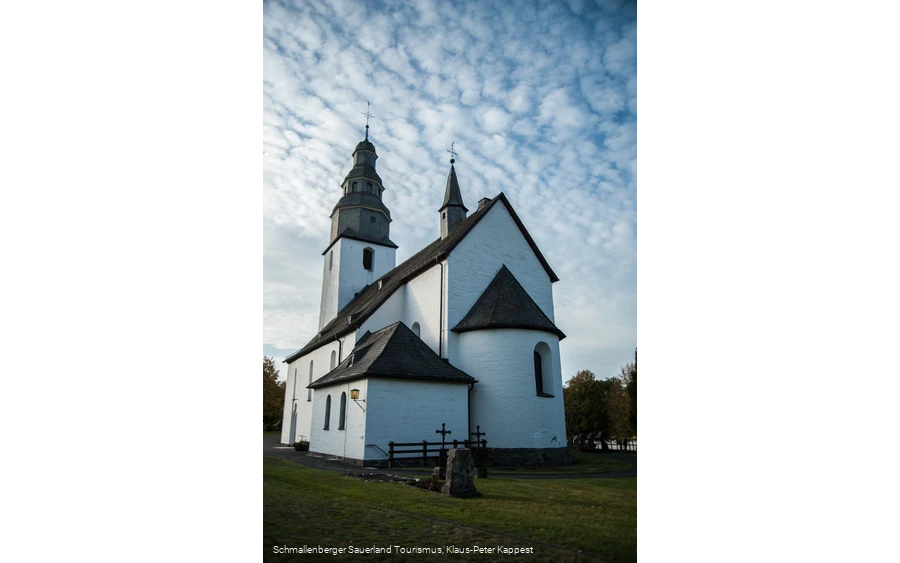 Rückseite der Kirche in Wormbach vor leicht bewölktem Himmel