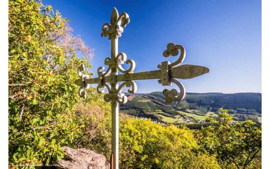 Weißes Metallkreuz auf dem Rinsleyfelsen in Richtung Tal