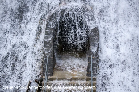 Das Wasser aus dem Diemelseeüberlauf sprundelt vor einer Tür
