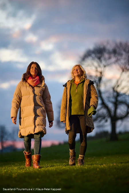 Zwei Frauen wandern im Winterlicht