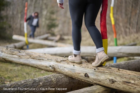 Füße balancieren über ein großes Baummikado