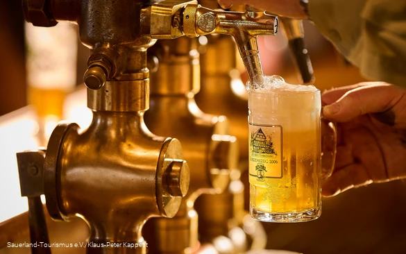 Ein schäumendes Bier wird frisch gezapft