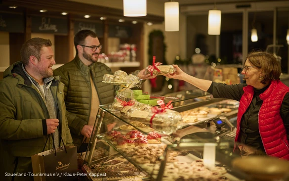 Zwei Männer kaufen einen weihnachtsstollen in einem Geschäft