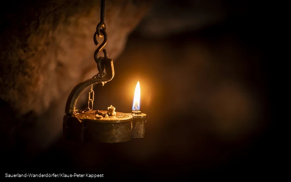 Kleine Lampe leutet im dunklem Philippstollen in Olsberg