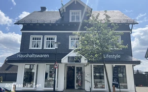 Ein dreistöckiges Haus mit Verkaufsräumen im Erdgeschoss.jpg