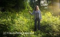 Frau mit Pilgerstab auf dem Uplaender Besinnungsweg