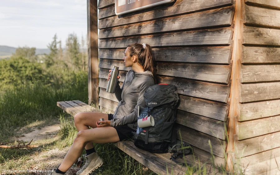 Wanderin macht Pause an der Schutzhütte am Aussichtspunkt "Westerwaldblick"