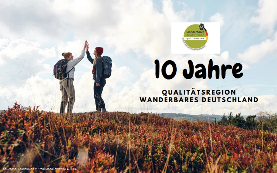 Zwei Frauen klatschen sich mit erhobenen Händen ab - 10 Jahre Qualitätsregion Wanderbares Deutschland