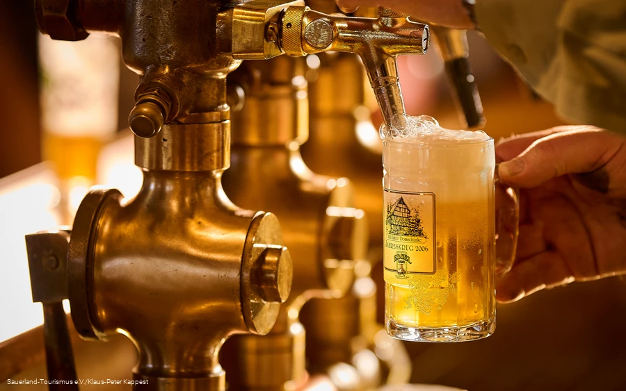 Ein schäumendes Bier wird frisch gezapft Ein schäumendes Bier wird frisch gezapft