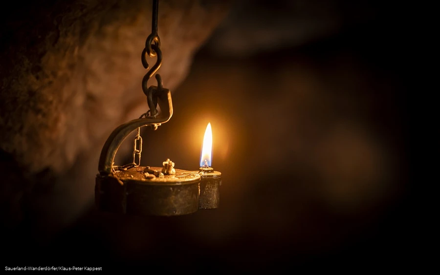 Kleine Lampe leutet im dunklem Philippstollen in Olsberg