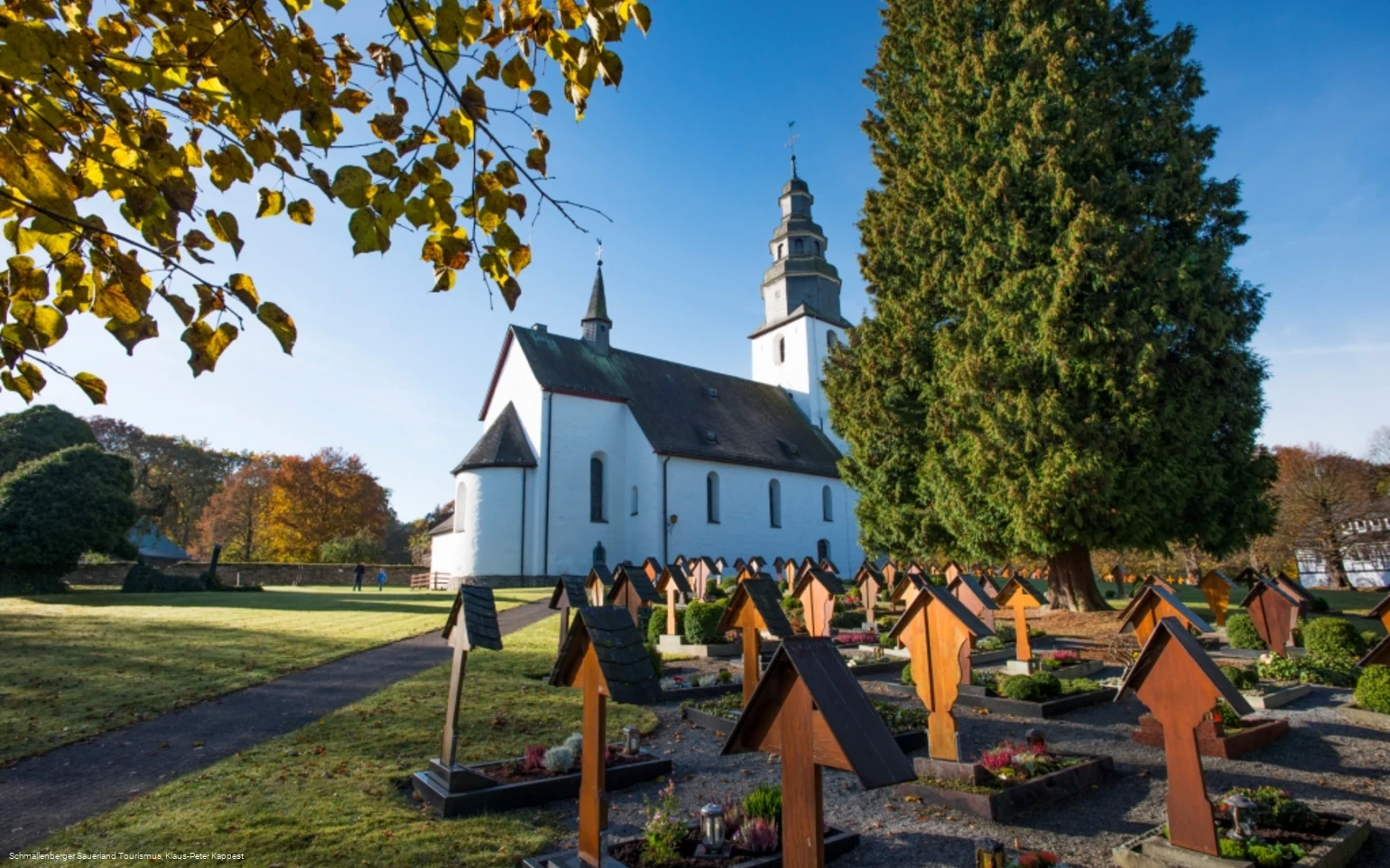 Die Kirche St. Peter und Paul mit Friedhof an einem Herbsttag in der Sonne