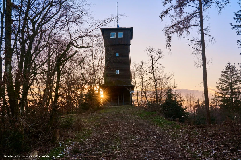 Ein Turm im Gegenlicht beim Sonneuntergang
