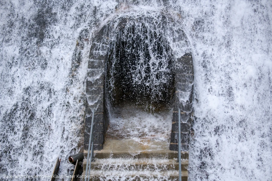 Das Wasser aus dem Diemelseeüberlauf sprundelt vor einer Tür