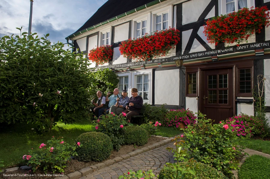 Männer trinken ein Feierabendbierchen vor Fachwerkkulisse