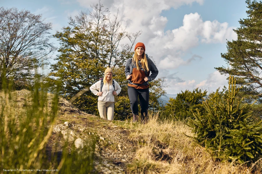 Zwei Frauen wandern &uuml;ber einen H&uuml;gel am Antoniussteig