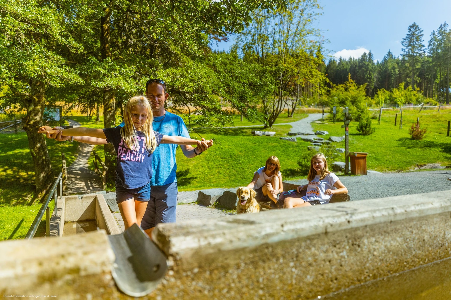 Familie am Tretbecken an der Diemelquelle