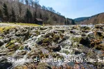 Das Wasser fließt über Steine aus dem Überlauf des Schmalahsees