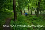 Ein Mann sitzt auf einer Parkbank am Teich vom Kloster Flechtorf