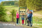 Familie am Kuhglockenspiel auf dem Milch-Erlebnispfad Usseln