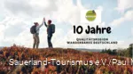 Zwei Frauen klatschen sich mit erhobenen Händen ab - 10 Jahre Qualitätsregion Wanderbares Deutschland