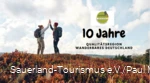 Zwei Frauen klatschen sich mit erhobenen Händen ab - 10 Jahre Qualitätsregion Wanderbares Deutschland