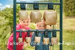 Kinder am Kuhglockenspiel auf dem Milch-Erlebnispfad Usseln