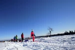 Familie mit Kindern auf Schlitten wandert auf dem Ettelsberg 