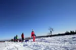 Familie mit Kindern auf Schlitten wandert auf dem Ettelsberg 