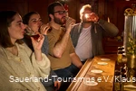Vier Menschen probieren ein Bier während einer Bierprobe