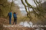zwei Wanderer fotografieren einen Bieberbau am Diemelsee