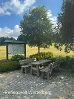 Informationstafel mit Wanderwegen in und um Lenneplätze neben zwei Bänken mit einem Tisch.